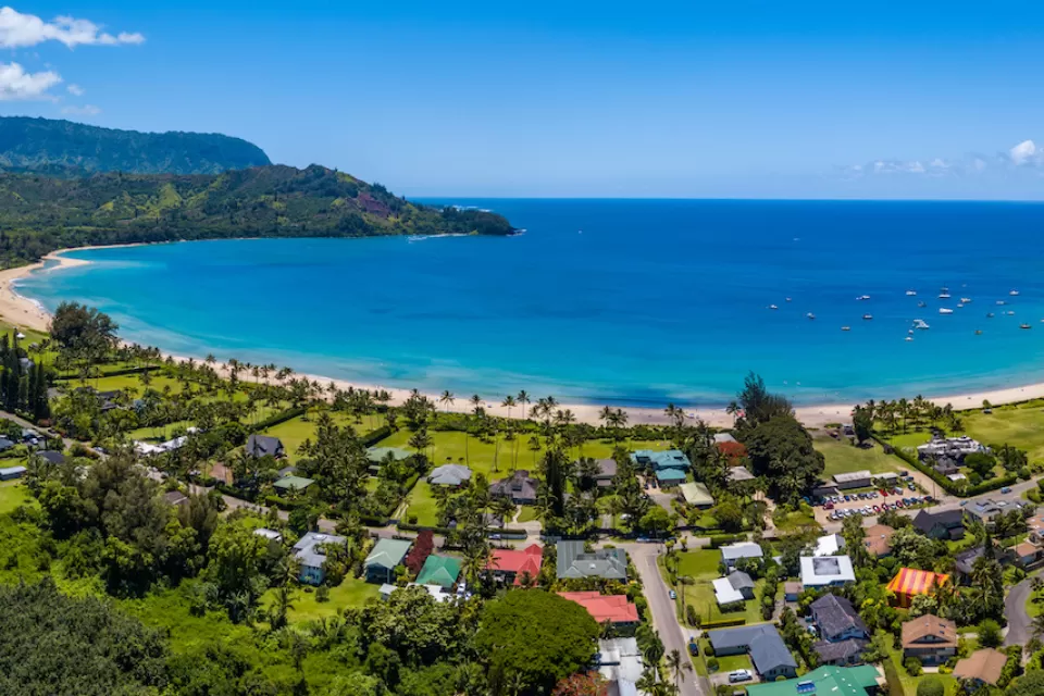 Aerial view of coastal development and bright blue ocean in Kaua'i, Hawai'i.